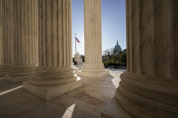 FILE - The Supreme Court is seen in Washington, with the U.S. Capitol in the distance, Nov. 4, 2020. It's hard to imagine a less contentious or more innocent word than “and.” But how to interpret the simple conjunction has prompted a complicated legal fight that lands in the Supreme Court on the first day of its new term next week. What the justices decide could affect thousands of prison sentences each year. (AP Photo/J. Scott Applewhite, File)