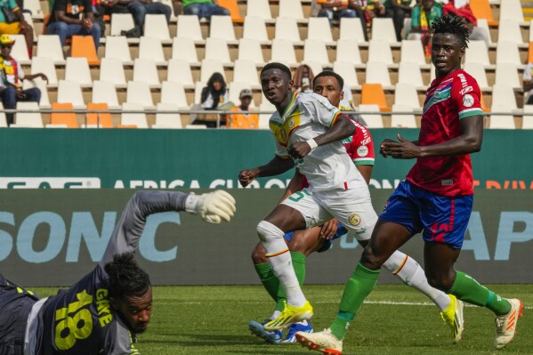 Senegal's Lamine Camara, center, gestures as he scores his side's second goal past Gambia's goalkeeper Baboucarr Gaye, bottom left, during the African Cup of Nations Group C soccer match between Senegal and Gambia at the Charles Konan Banny stadium in Yamoussoukro, Ivory Coast, Monday, Jan. 15, 2024. (AP Photo/Sunday Alamba)