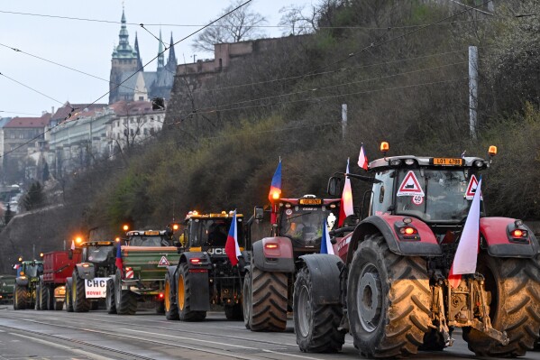 A convoy of tractors drives on a street during a farmers' protest in Prague, March 7, 2024. Czech farmers have blocked traffic in Prague, cramming the streets with hundreds of tractors and other vehicles as they rallied against the government and agriculture policies set by the European Union.(Katerina Sulova/CTK via AP) ** SLOVAKIA OUT **