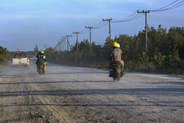 Workers ride their motorbikes on a road leading to the construction site of the Kalimantan Industrial Park Indonesia (KIPI) in Mangkupadi, North Kalimantan, Indonesia on Thursday, Aug. 24, 2023. The industrial park being built in Indonesia on the tropical island of Borneo that has attracted billions of dollars in foreign and domestic investment is damaging the environment in an area where endangered species live and migrate. (AP Photo/Yusuf Wahil)