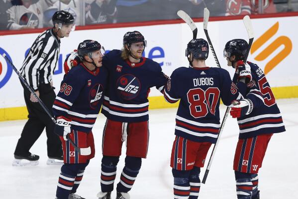 Winnipeg Jets' Nate Schmidt (88), Kyle Connor (81), Pierre-Luc Dubois (80) and Mark Scheifele (55) celebrate after Connor's goal against the New Jersey Devils during second-period NHL hockey game action in Winnipeg, Manitoba, Sunday, April 2, 2023. (John Woods/The Canadian Press via AP)