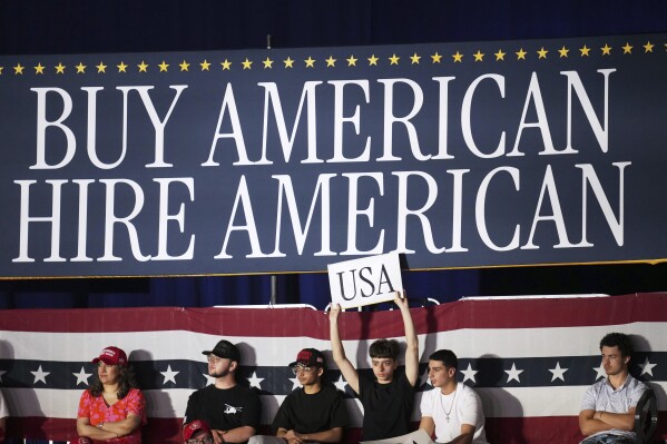 People arrive before President Donald Trump speaks on his first 100 days at Macomb County Community College Sports Expo Center, Tuesday, April 29, 2025, in Warren, Mich. (AP Photo/Paul Sancya)