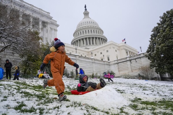 Younger folks escape every totally different down the sledding hill at the U.S. Capitol, as colleges are closed because of a winter snow fall, Tuesday, Jan. 16, 2024. (AP Describe/Jacquelyn Martin)