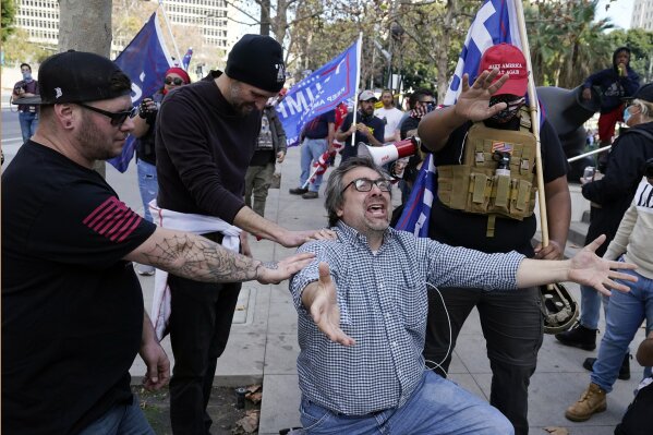 Demonstrators pray during a pro-Trump rally outside of City Hall Wednesday, Jan. 6, 2021, in Los Angeles. Demonstrators, supporting President Donald Trump, are gathering in various parts of Southern California as Congress debates to affirm President-elect Joe Biden's electoral victory. (AP Photo/Marcio Jose Sanchez)