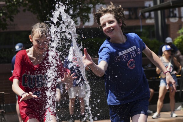 Kid cool off at a fountain during hot weather in Chicago, Sunday, June 22, 2025. (AP Photo/Nam Y. Huh)