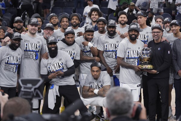 The Dallas Mavericks pose for a team photograph after a win over the Minnesota Timberwolves in Game 5 of the Western Conference finals in the NBA basketball playoffs Thursday, May 30, 2024, in Minneapolis. The Mavericks won 124-103, taking the series 4-1 and moving on to the NBA Finals. (AP Photo/Abbie Parr)