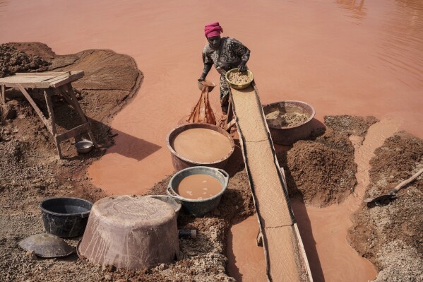 A woman processes gold at a mining site in the Kedougou region of Senegal on Thursday, Jan. 16, 2025. (AP Photo/Annika Hammerschlag)