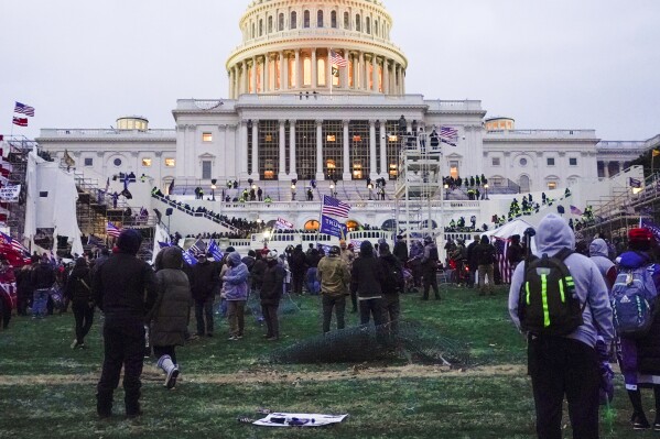 Rioters walk on the West Front at the U.S. Capitol on Jan. 6, 2021, in Washington. Democracy scholars are warning that political parties must accept the results of fair elections, reject violence and break ties to extremists. (AP Photo/Julio Cortez)