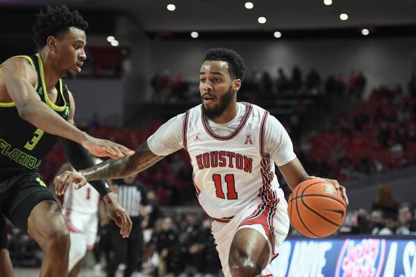 Houston guard Kyler Edwards (11) drives to the basket against South Florida forward DJ Patrick (3) during the first half of an NCAA college basketball game Tuesday, Jan. 18, 2022, in Houston. (AP Photo/Justin Rex)