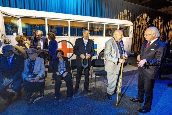 Sweden's King Carl Gustaf, right, and Queen Silvia meet with Holocaust survivors at an exhibition showing the "White Buses", used in a Red Cross rescue action in 1945, during the International Forum on Holocaust Remembrance and Combating Antisemitism, in Malmoe, Sweden, Wednesday, Oct. 13, 2021. The one-day conference focuses on the receding memory of the Holocaust as Sweden marks the 20th anniversary of a conference on remembering the genocide, with participants focusing on how social media is contributing to a rise in antisemitism. ( Jonas Ekströmer/TT via AP)