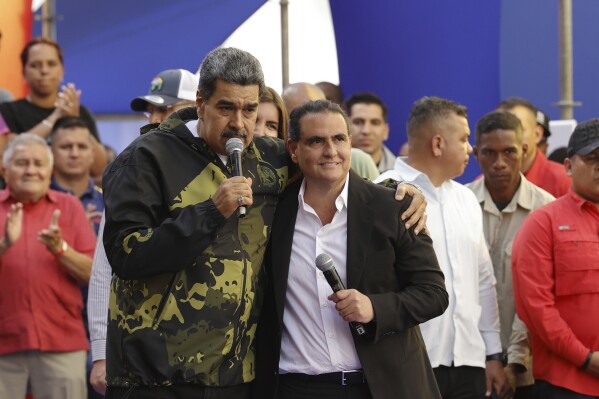 Venezuela's President Nicolas Maduro and Alex Saab stand in an embrace during an event marking the anniversary of the 1958 coup that overthrew dictator Marcos Perez Jimenez, in Caracas, Venezuela, Tuesday, Jan. 23, 2024. (AP Photo/Jesus Vargas)