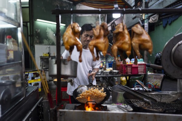 2024 年 1 月 27 日星期六，餐厅老板 Hien Ky 在越南胡志明市准备炒饭。越南是世界第三大大米出口国，湄公河三角洲对越南文化的主要重要性显而易见。  （美联社照片/Jae C. Hong）