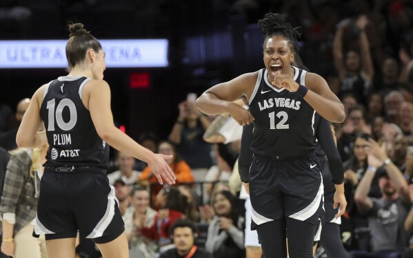 Las Vegas Aces guards Chelsea Gray (12) and Kelsey Plum (10) celebrate a play during the first half of an WNBA basketball game against the Seattle Storm Wednesday, June 19, 2024, in Las Vegas. (Steve Marcus/Las Vegas Sun via AP)