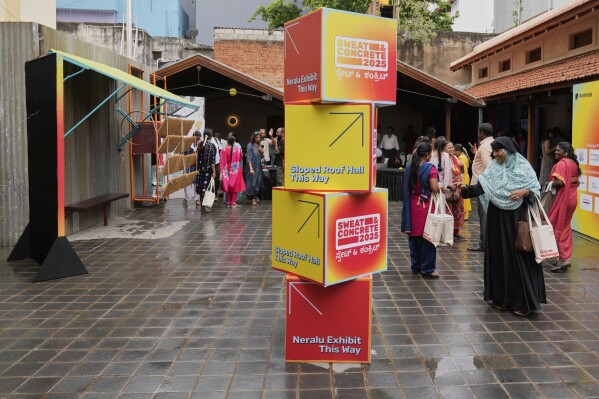 Daily wage workers, who mostly work outdoors, leave after exploring Neralu, an innovative portable heat shelter, at the Sweat and Concrete 2025 event in Bengaluru, India, Thursday, May 29, 2025. (AP Photo/Aijaz Rahi)