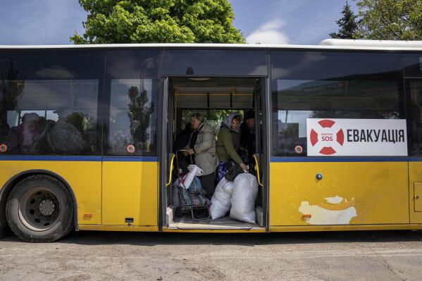 People stand in the bus during evacuation near Lyman, Ukraine, Wednesday, May 11, 2022. (AP Photo/Evgeniy Maloletka)