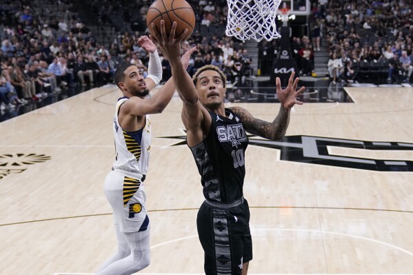 San Antonio Spurs forward Jeremy Sochan scores past Indiana Pacers guard Tyrese Haliburton (0) during the first half of an NBA basketball game in San Antonio, Sunday, March 3, 2024. (AP Photo/Eric Gay)