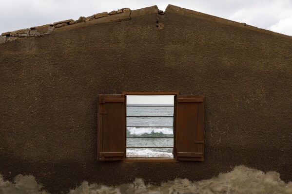 Waves are visible through a window of Atsu Godslove Afeli’s room, which was destroyed by coastal erosion in Avegadzi, Ghana, Wednesday, March 5, 2025 (AP Photo/Misper Apawu)