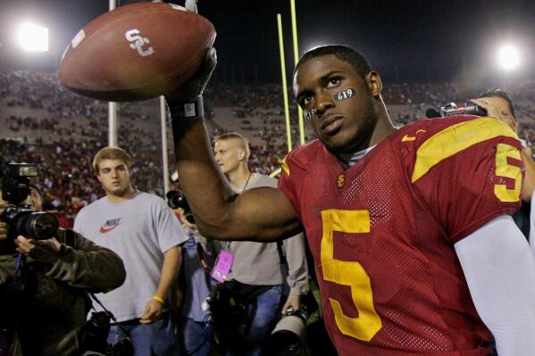 FILE - Southern California tail back Reggie Bush walks off the field holding the game ball after the Trojans defeated Fresno State, 50-42, at the Los Angeles Coliseum on Nov. 19, 2005. Reggie Bush, whose Heisman Trophy victory for Southern California in 2005 was vacated because of NCAA violations, was among 18 players in the latest College Football Hall of Fame class announced Monday, Jan. 9, 2023. (AP Photo/Kevork Djansezian, File)
