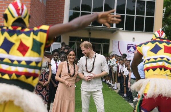 Prince Harry and Meghan visit children at the Lights Academy in Abuja, Nigeria, Friday, May 10, 2024. Prince Harry and his wife Meghan have arrived in Nigeria to champion the Invictus Games, which he founded to aid the rehabilitation of wounded and sick servicemembers and veterans. (AP Photo/Sunday Alamba)
