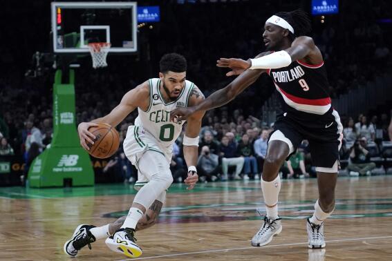 Boston Celtics forward Jayson Tatum (0) drives to the basket against Portland Trail Blazers forward Jerami Grant (9) during the first half of an NBA basketball game, Wednesday, March 8, 2023, in Boston. (AP Photo/Charles Krupa)