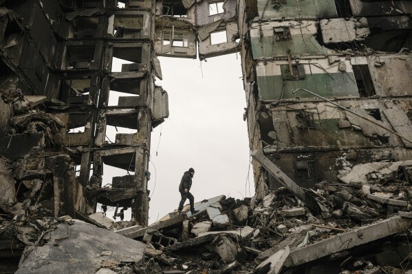 FILE - A resident looks for belongings in an apartment building destroyed during fighting between Ukrainian and Russian forces in Borodyanka, Ukraine, April 5, 2022. The GOP has been softening its stance on Russia ever since Donald Trump won the 2016 presidential election following Russian hacking of his Democratic opponents. The reasons include Russian President Vladimir Putin holding himself out as an international champion of conservative Christian values, the GOP's growing skepticism of international entanglements and Trump's own personal embrace of the Russian leader. Now the GOP's ambivalence on Russia has stalled additional aid to Ukraine. (APPhoto/Vadim Ghirda, File)