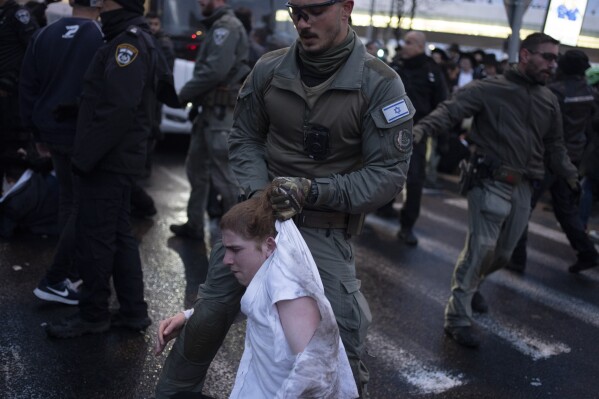 FILE - Israeli police officers scuffle with ultra-Orthodox Jewish men during a protest against a potential new draft law which could end their exemptions from military service in Jerusalem, on March 18, 2024. (AP Photo/Leo Correa, File)