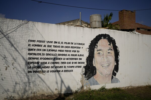 A mural of Claudio Ariel Cantero covers a wall alongside a supportive message of him written by his family, in Rosario, Argentina, Tuesday, April 9, 2024. Cantero, known as “El Pajaro,” or The Bird, was the leader of the criminal organization called “Los Monos,” or The Monkeys, and was shot to death at a bowling alley on May 26, 2013 in Santa Fe. (AP Photo/Natacha Pisarenko)