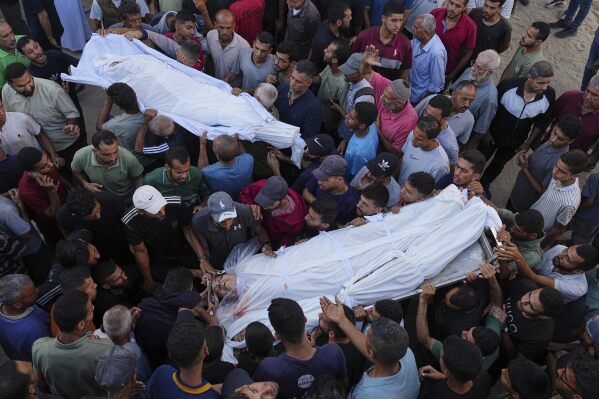 Palestinians carry the bodies of relatives who were killed in an Israeli military strike on Gaza, at Al-Shifa Hospital in Gaza City, Thursday, June 19, 2025. (AP Photo/Jehad Alshrafi)