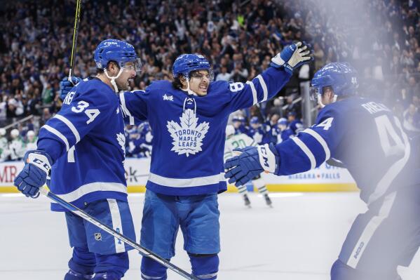 Toronto Maple Leafs left wing Nicholas Robertson (89), center Auston Matthews (34) and defenseman Morgan Rielly (44) celebrate after Robertson's overtime goal during NHL hockey game action against the Dallas Stars in Toronto, Thursday, Oct. 20, 2022. (Cole Burston/The Canadian Press via AP)