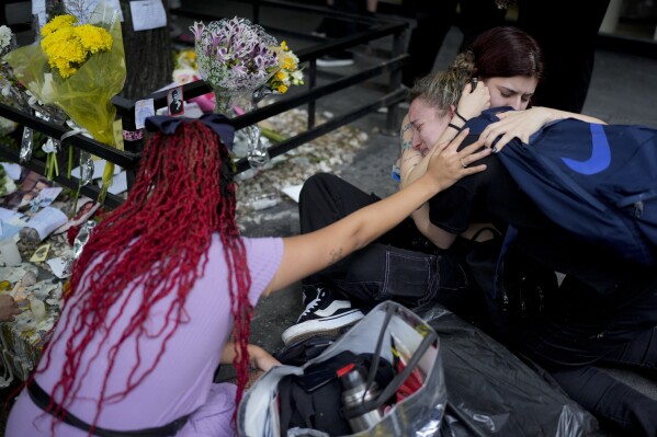 Fans of former One Direction singer Liam Payne gather outside the hotel where he was found dead after falling from a balcony in Buenos Aires, Argentina, Thursday, Oct. 17, 2024. (AP Photo/Natacha Pisarenko)