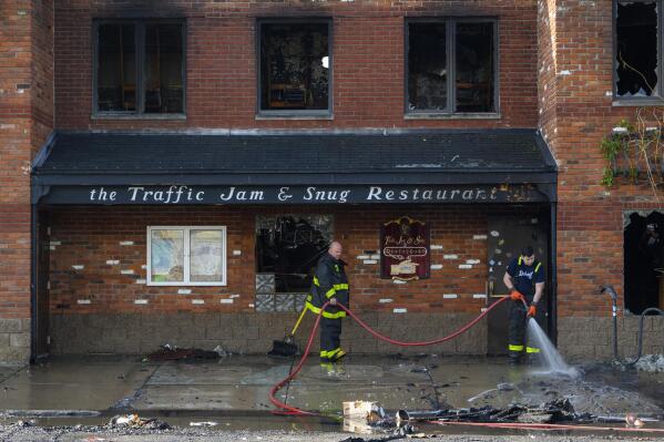 Detroit firefighters clean up in front of Traffic Jam and Snug Restaurant,  after an overnight fire, Friday, May 27, 2022. (Andy Morrison/Detroit News via AP)