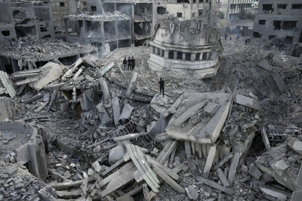 Palestinians inspect the rubble of the Yassin Mosque destroyed after it was hit by an Israeli airstrike at Shati refugee camp in Gaza City, early Monday, Oct. 9, 2023. (AP Photo/Adel Hana)