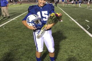 
              In this Friday, Sept. 7, 2018 photo provided by the Ocean Springs School District, Ocean Springs High School’s 2018 Homecoming Queen Kaylee Foster holds her football helmet while wearing a tiara on the field in Ocean Springs, Miss. The high school senior was crowned homecoming queen before the football game where she kicked the winning field goal to lead her team to victory. (Justin Sutton/Ocean Springs School District via AP)
            