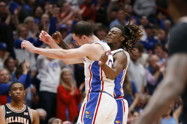 El guardia de Kansas, Nicolas Timberlake, izquierda, celebra anotar una canasta de tres puntos con Jamari McDowell durante la primera mitad de un partido de baloncesto universitario de la NCAA contra Oklahoma State, el martes 30 de enero de 2024, en Lawrence, Kansas (AP Photo/Colin E .braley)