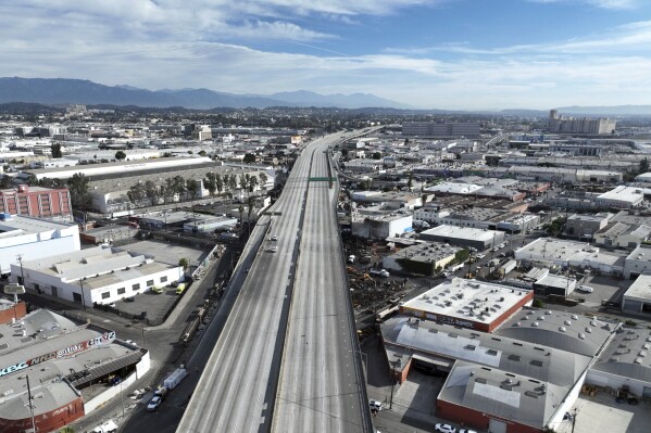 In this aerial view, Interstate 10 is empty due to a closure in the aftermath of a fire, Monday, Nov. 13, 2023, in Los Angeles. Los Angeles drivers are being tested in their first commute since a weekend fire that closed a major elevated interstate near downtown. (AP Photo/Jae C. Hong)