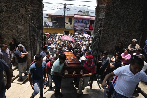 FILE - Relatives and friends carry the coffin that contains the remains of a man slain in a mass shooting, into a church for a funeral service in Huitzilac, Mexico, May 14, 2024. When Mexicans vote June 2, they will do so in an increasingly polarized country that continues to struggle with staggering levels of violence. (AP Photo/Fernando Llano, File)