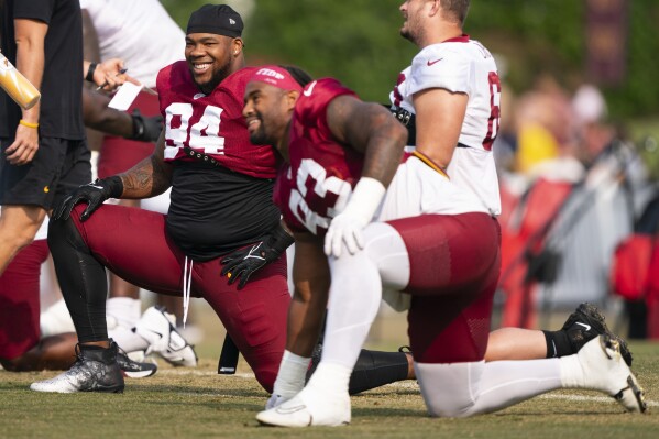 Washington Commanders defensive tackle Daron Payne, left, and defensive tackle Jonathan Allen warm up during an NFL football practice at the team's training facility, Wednesday, Aug. 2, 2023, in Ashburn, Va. (AP Photo/Evan Vucci)
