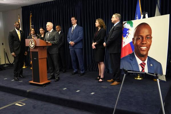 Matthew Olsen, Assistant Attorney General for National Security, speaks during a news conference, Tuesday, Feb. 14, 2023, in Miami. U.S. authorities have arrested four more people in the slaying of Haitian President Jovenel Moïse, including the owner of a Miami-area security company that hired former soldiers from Colombia for the mission. At left is Markenzy Lapointe, U.S. Attorney for the Southern District of Florida. At right is an image of Haitian President Jovenel Moïse, (AP Photo/Lynne Sladky)