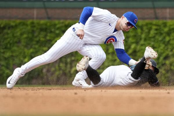 Chicago Cubs second baseman Nico Hoerner catches Miami Marlins' Jon Berti trying to steal second off a throw from catcher Tucker Barnhart during the fifth inning of a baseball game, Saturday, May 6, 2023, in Chicago. (AP Photo/Charles Rex Arbogast)