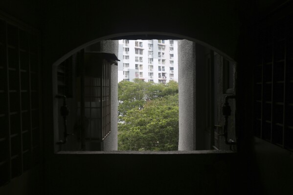 The outside is seen through an open window in an apartment hallway in Kuala Lumpur, Malaysia, on Oct. 7, 2023. The building is home to several underage Rohingya girls who entered into arranged marriages with older men. (AP Photo/Victoria Milko)