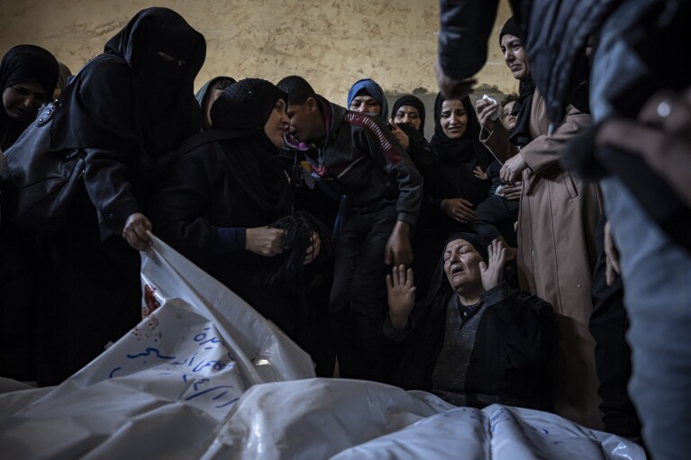 Miembros de la familia Abu Sinjar lloran a sus familiares muertos en el bombardeo israelí de la Franja de Gaza, en su casa en Rafah, sur de Gaza, el viernes 5 de enero de 2024. (Foto AP/Fatima Shbair)