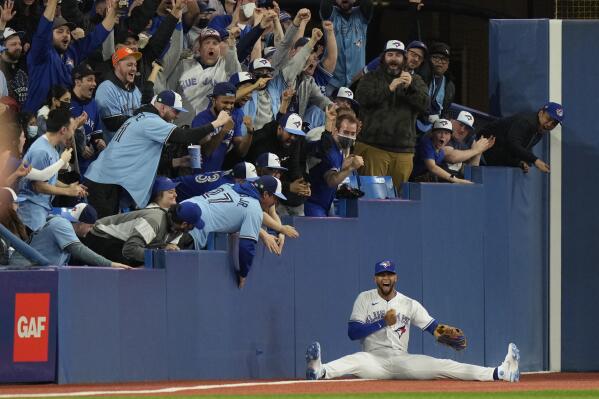 Toronto Blue Jays left fielder Lourdes Gurriel Jr. and fans celebrate his catch against the Texas Rangers' Mitch Garver during the ninth inning of a baseball game Friday, April 8, 2022, in Toronto. (Frank Gunn/The Canadian Press via AP)