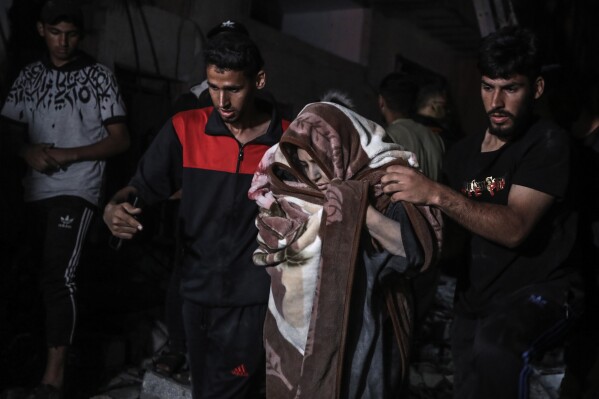 Palestinians rescue a woman survived after the Israeli bombardment on a residential building of Abu Alenan family in Rafah, southern Gaza Strip, early Saturday, May 4, 2024. (AP Photo/Ismael Abu Dayyah)