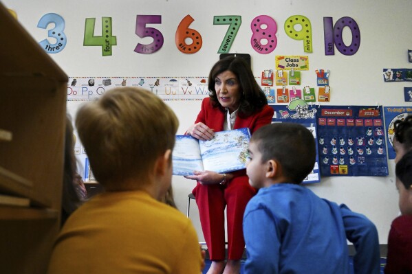 FILE - New York Gov. Kathy Hochul reads "Snowflakes Fall" to daycare children at the Department of Labor, Dec. 20, 2023, in Albany, N.Y. Hochul on Wednesday, Jan. 3, 2024, said she will push for schools to reemphasize phonics in literacy education programs, a potential overhaul that comes as many states revamp curriculums amid low reading scores. (Will Waldron/The Albany Times Union via AP, File)