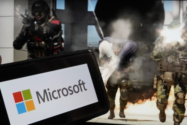 FILE - The logo for Microsoft, and a scene from Activision "Call of Duty - Modern Warfare," are shown in this photo, in New York, Wednesday, June 21, 2023. Microsoft reports earnings on Tuesday, Oct. 24, 2023. (AP Photo/Richard Drew, File)