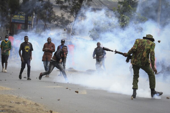 Protesters throwing rocks and police firing tear gas clash in the Mathare neighborhood of Nairobi, Kenya Wednesday, July 12, 2023. Kenyans angered by the rising cost of living were back protesting on the streets of the capital, Nairobi, on Wednesday, as they awaited a speech by a longtime opposition leader. (AP Photo)