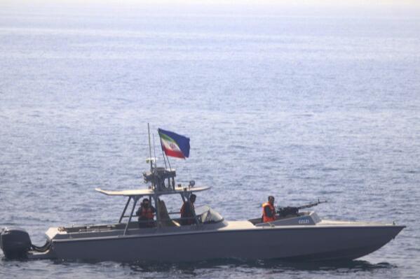 In this photo made available by the U.S. Navy, a boat of Iran's Islamic Revolutionary Guard Corps Navy (IRGCN) operates in close proximity to patrol coastal ship USS Sirocco (PC 6) and expeditionary fast transport USNS Choctaw County (T-EPF 2) in the Strait of Hormuz, Monday, June 20, 2022. A U.S. Navy warship fired a warning flare to wave off an Iranian Revolutionary Guard speedboat coming straight at it during a tense encounter in the strategic Strait of Hormuz, officials said Tuesday. (U.S. Navy via AP)