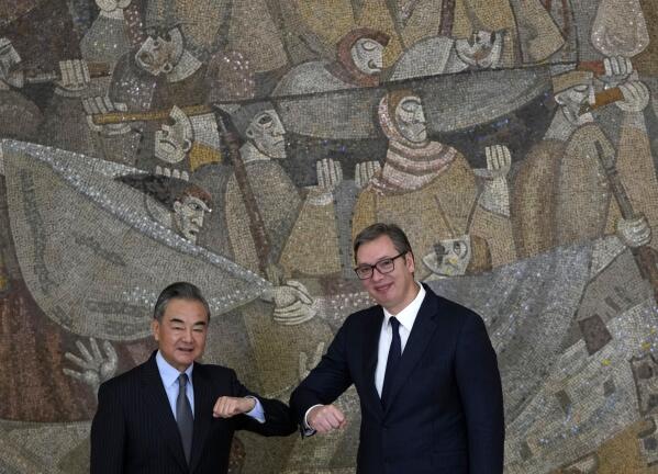 Chinese Foreign Minister Wang Yi, left, elbow bumps with Serbian President Aleksandar Vucic after a news conference at the Serbia Palace in Belgrade, Serbia, Thursday, Oct. 28, 2021. Wang Yi is on a two-day official visit to Serbia. (AP Photo/Darko Vojinovic)