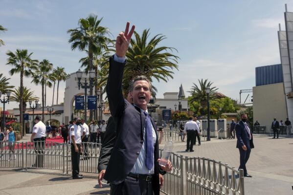 FILE - In this June 15, 2021 file photo California Governor Gavin Newsom gestures after a news conference at Universal Studios in Universal City, Calif. On Thursday, June 17, 2021, Newsom released his first ads in the recall campaign against him, with one highlighting recent positive news including cash payments to Californians. (AP Photo/Ringo H.W. Chiu, File)