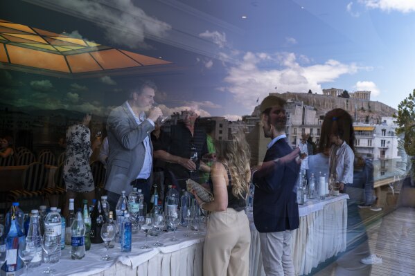 The ancient Parthenon temple is reflected in a window as people sip samples of fine water during an international water tasting competition held in Athens, Greece, on Wednesday, April 26, 2023. This year’s champions in each category, from still water to sparkling and super-low minerality to high, came from Austria, New Zealand, Panama, Scandinavia and other parts of the world. (AP Photo/Petros Giannakouris)